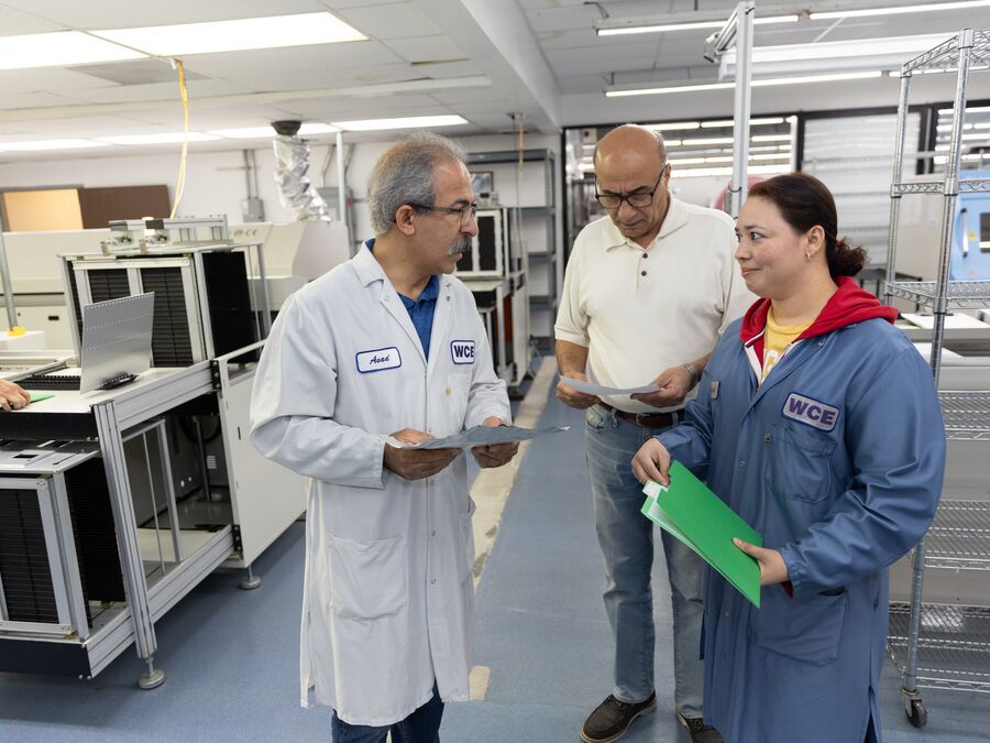 WCE engineering and production staff reviewing build documentation on the floor